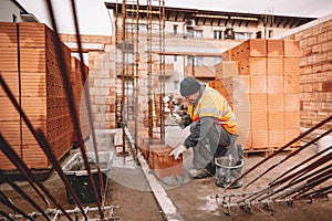 Close up of industrial bricklayer mason installing bricks