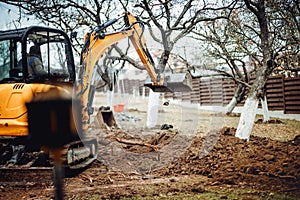 Close up of industrial bulldozer scoop moving earth and doing landscaping works