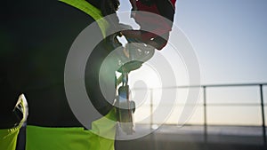 Close-up of an industrial climber fastening a carabiner with a jumar to a harness