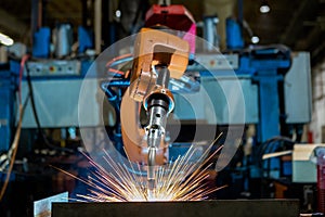 Close-up industrial robot is welding in a car factory