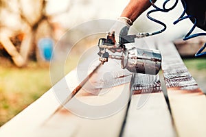 Industrial worker using paint gun or spray gun for applying paint