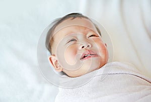 Close up Infant baby boy crying and screaming lying on bed