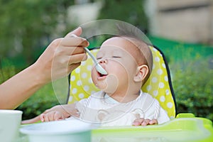 Close-up infant baby boy feeding with food stain on her mouth