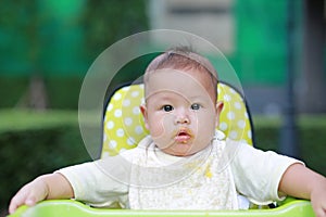 Close-up infant baby boy feeding with food stain on her mouth