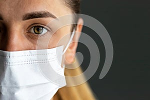 Close up of infected girl on dark background in medical protective mask. Concept of infection control. Medical concept.