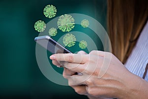 Close up of infected smartphone. Coronavirus cells on the phone surface, heldin hands. Virus spread, coronavirus prevention