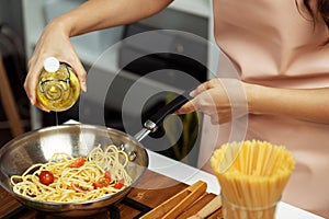 Close up influencer cooking spaghetti mix ingredient to frying pan. Postulate.