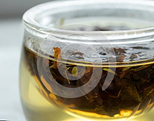 Close-up infusing herbal tea in glass mug