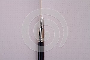 Close-up ink pen on the blank copy book.