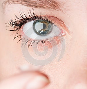 Close up of inserting a contact lens in female eye