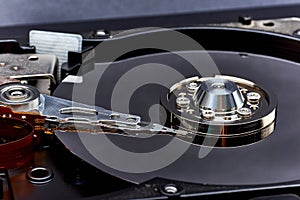 Close up inside of Hard disk drive HDD . Detail of writing/reading head on acuator arm and axis, spindle and platters