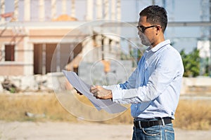 Close up inspector checking blueprint for industry construction