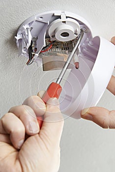 Close Up Of Installing Smoke Detector At Home