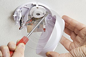 Close Up Of Installing Smoke Detector At Home photo