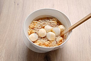 Close up Instant noodle with meatballs on wooden background.