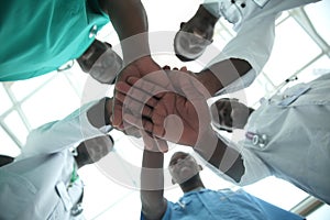 Close up. international group of doctors putting their hands together