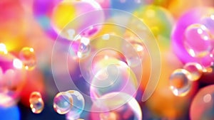 Close-up of iridescent soap bubbles floating on a vibrant rainbow background. Concept of joy, childhood, lightness