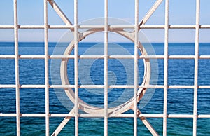 Close up of Iron fence with blue sea in background