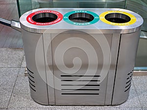 Close-up of an iron garbage can. Sorting garbage into plastic, paper and unsorted waste is marked with different colors. Cleaning