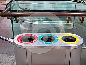 Close-up of an iron garbage can. Sorting garbage into plastic, paper and unsorted waste is marked with different colors. Cleaning