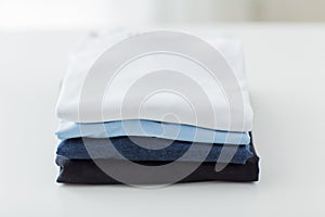 Close up of ironed and folded t-shirts on table photo