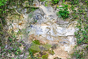 Close-up of an irregular and cracked limestone wall of a hill