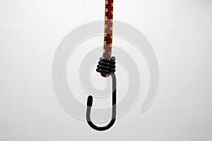 Close up of isolated black metal hook with elastic rope, white background focus on center