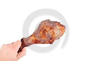 Close up and isolated image of hand holding a grilled turkey leg on white background.