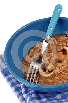 Plate of mushroom risotto with fork close-up on white background photo