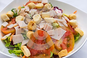 Close up of italian organic mixed vegetable salad with ham and t