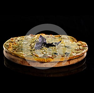 Close up italy hot pizza with cheese and purple basil isolated on black background