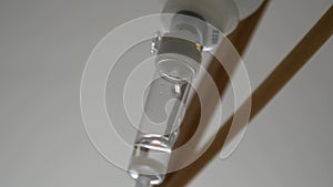 Close-up of an IV dropper in a hospital, dripping beads of saline solution in an intensive therapy room