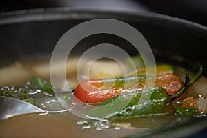 Close up of a jalapeño floating in broth