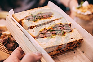 Close up of Japanese medium rare Wagyu sandwich served in wooden box