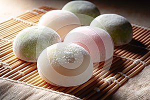 close-up of Japanese mochi on a bamboo mat. The mochi is soft, round, and gently dusted with a fine white powder