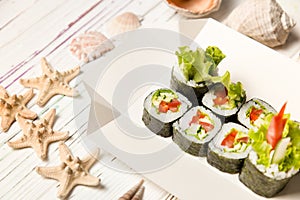 Close-up of Japanese Veggie Futomaki Sushi Roll pieces with fresh vegetables on carton delivery takeaway box on wooden background