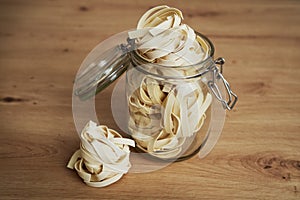 Close up of jar full of raw tagliatelle on the kitchen counter