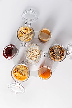 close up of jars with oat, corn flakes and granola