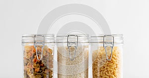 close up of jars with rice and pasta on table