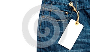 Close-up jeans with blank cardboard white price tag for your text. Label white price tag mock-up on blue jeans.