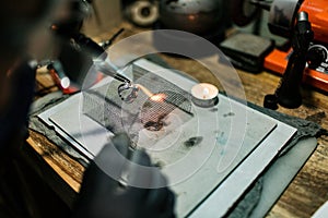 Close-up. The jeweler makes a silver ring