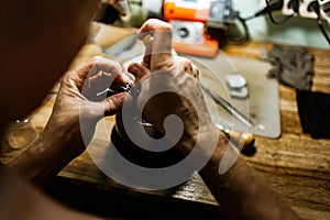 Close-up. The jeweler makes a silver ring