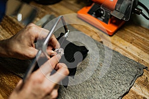 Close-up. The jeweler makes a silver ring