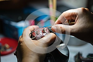 Close up of a jeweler`s hands doing a repair.