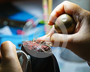 Close up of a jeweler`s hands doing a repair.
