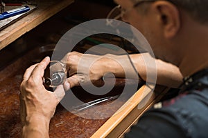 Close-up of a jeweler's hands polishing a gold bracelet