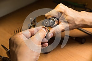 Close-up of a jeweler's hands polishing a gold ring