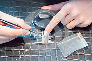 Close-up of jeweler sorting diamonds on her workbench