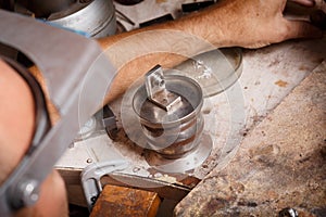 Close-up of a jeweler at work on a workshop background. Crafts equipment. Handmade jewelry concept.