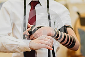 A close-up of a Jewish bar mitzvah boy, wearing a white shirt,